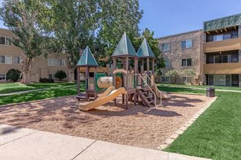 A playground with a slide and two towers.
